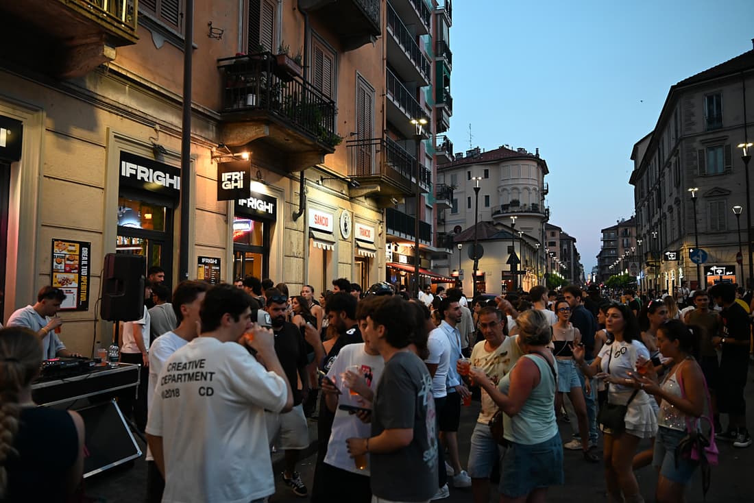 La via piena di gente davanti al locale